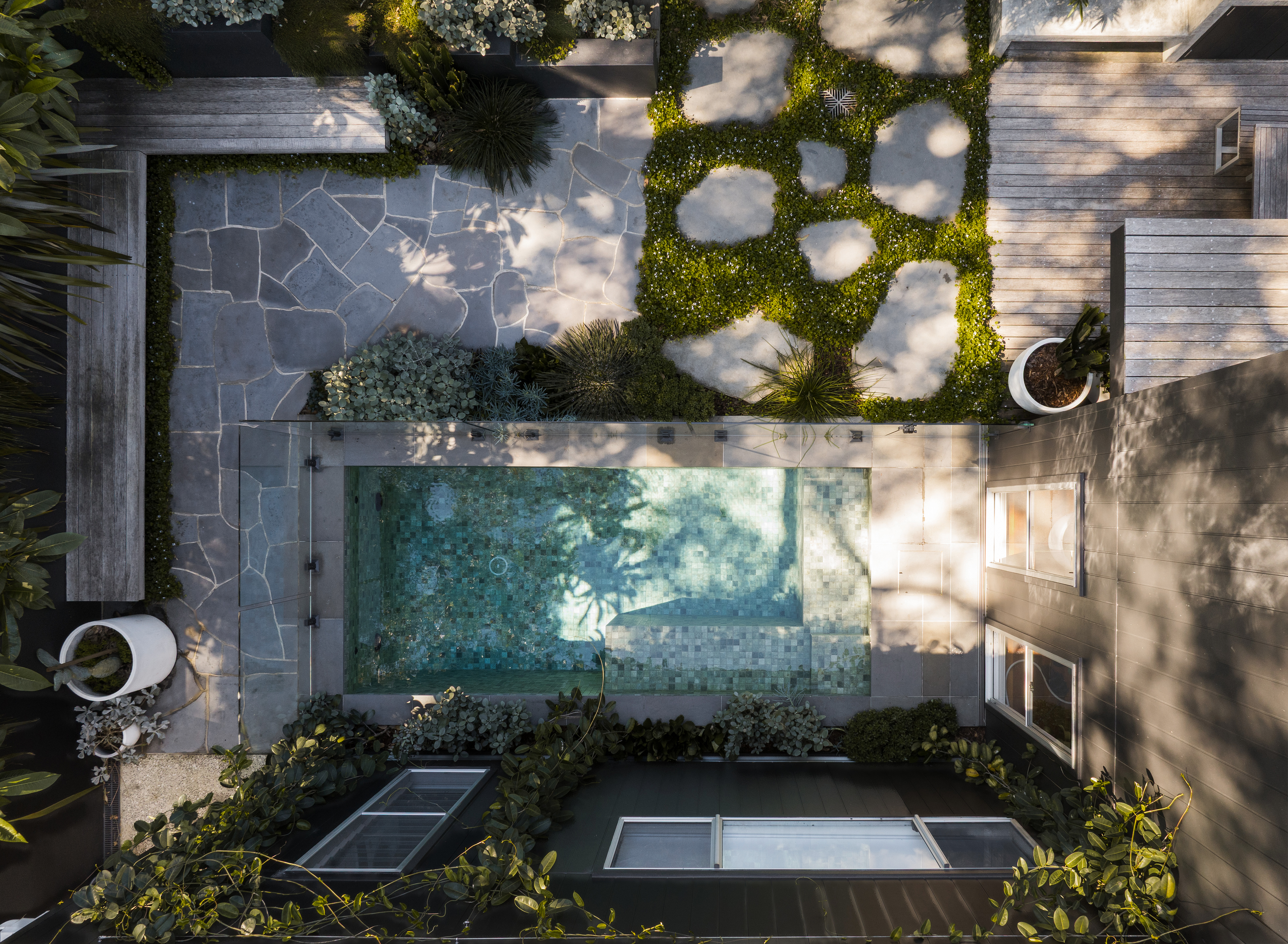 Fully tiled concrete plunge pool in a Coledale courtyard, seen from inside the house